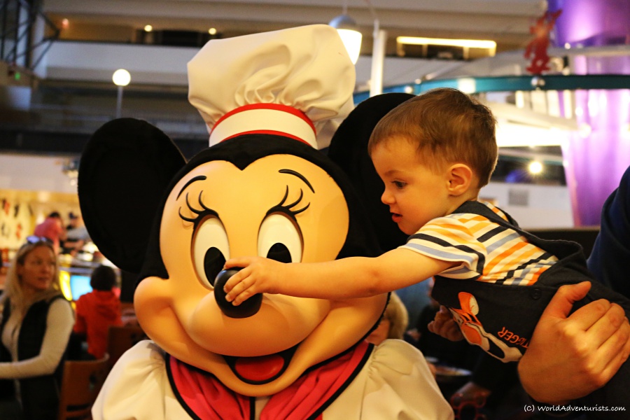 Little boy honking Minnie's nose at Chef Mickey's