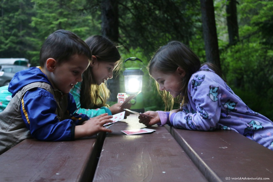 Kids playing cards camping at Birkenhead Lake in Pemberton, BC